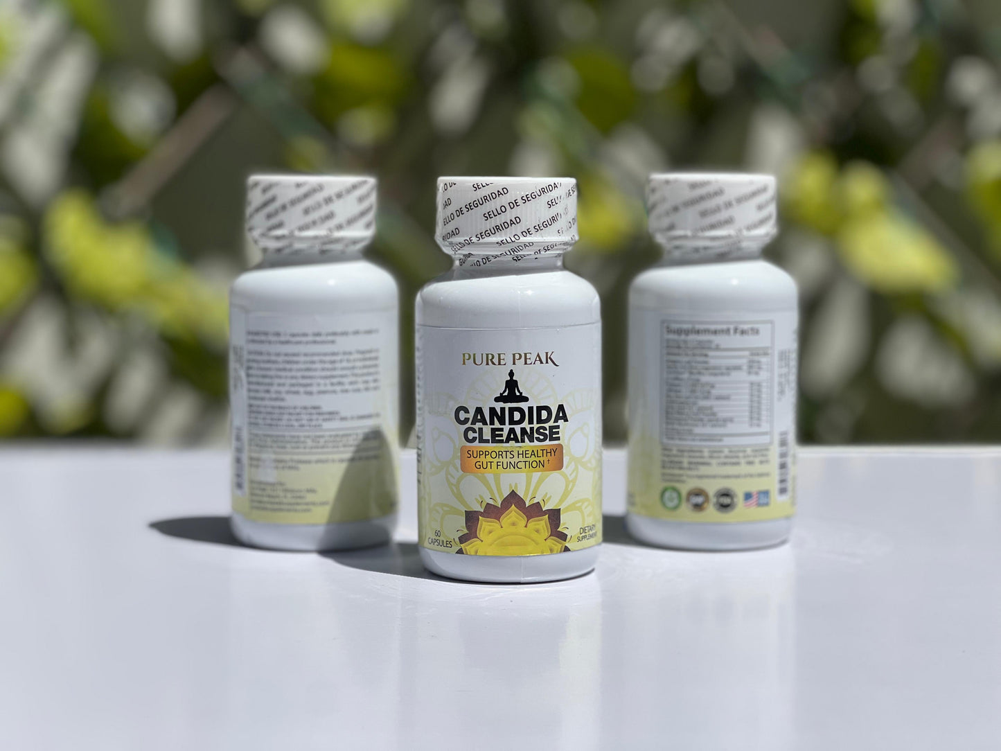 Candida Cleanse supplement bottles on a table with greenery background.